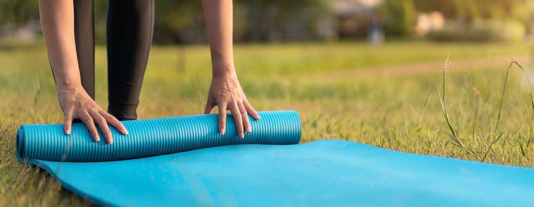 resident rolls up her yoga mat on lawn